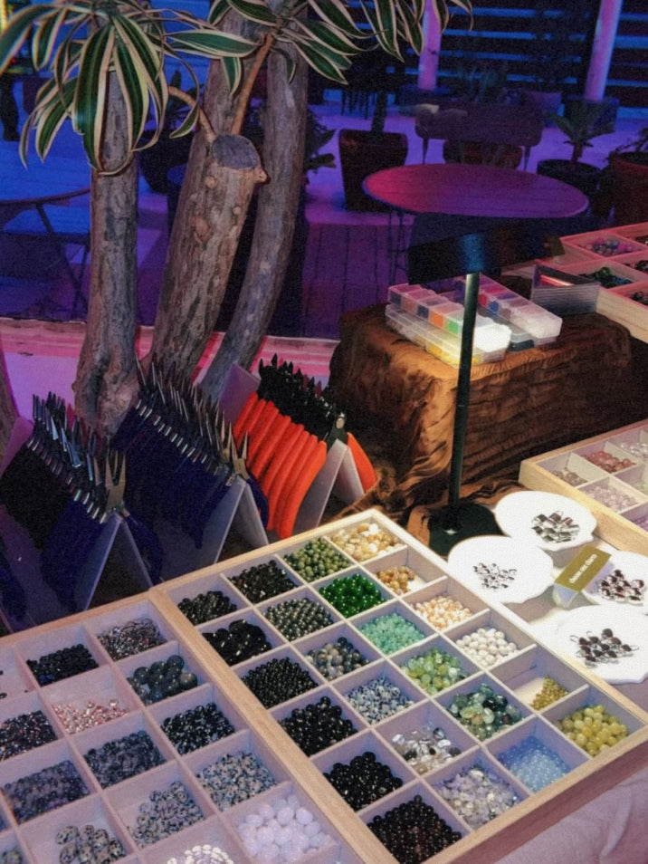 Display of beads in a box with a plant and table in the background